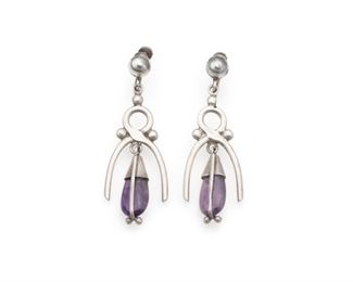 1178
A Pair Of Antonio Pineda Silver And Amethyst Earrings
1953-1979; Taxco, Mexico
Crown mark for Antonio Pineda, Eagle 7
The stylized wishbone-motif screw-back earrings featuring teardrop amethysts, 2 pieces
Each: 2.25" H x .75" W
14.5 grams
Estimate: $300 - $500