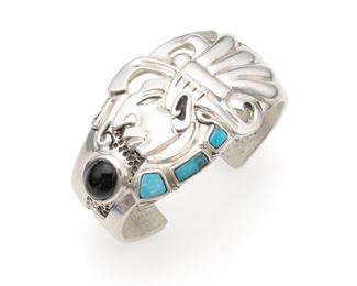 1192
A Sergio Gomez Silver Cuff Bracelet
Third-quarter 20th Century; Mexico
Stamped: Sergio Gomez / 980
Centering an Aztec-style figure set with turquoise and a brown stone
6.25" C x 1.5" H, wrist opening: 1"
109.0 grams
Estimate: $300 - $500