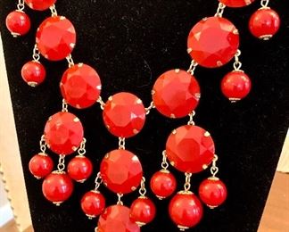 Close up of red statement necklace.