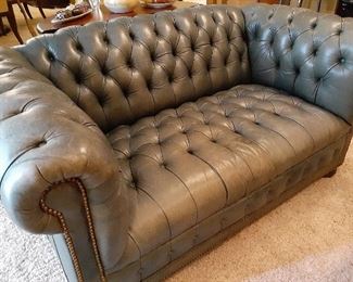 Tufted green leather loveseat