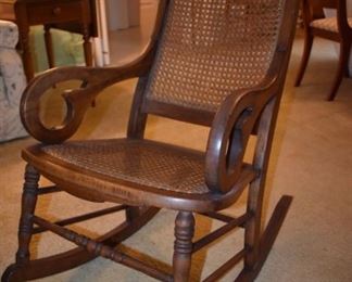 Antique Rocker in the family since the mid 1800's in Fantastic Condition featuring Beautifully styled arms with Spool style legs, with Cane Seat and Back