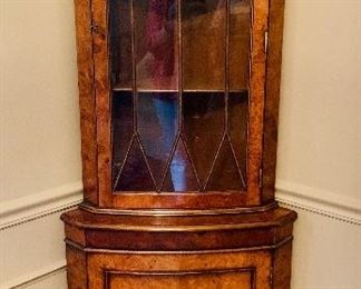 $450 Glass front burl wood corner display cabinet with shelves. 71"H x 27.5"W x 14"D (each side is 18" long); missing 2 inch piece of moulding