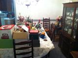dining room table (covered by cloth), candles, faux flowers, dining room chairs, china, china cabinets
