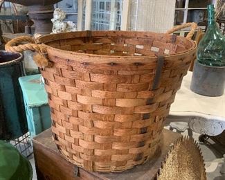 Large antique handwoven basket with rope handles and metal braces