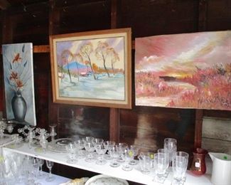 Art work is hanging all over and some lined up against the garage wall