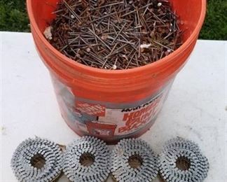 5 gallon bucket full of nails and rolls of siding nails