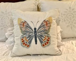 White lace bed linen with a butterfly pillow.
