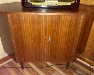 Vintage Danish Modern corner cabinet with key. Small chip on bottom of front door, as shown.