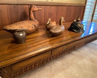 Large vintage coffee table by Baker.  Solid wood duck decoys and vintage German helmet.