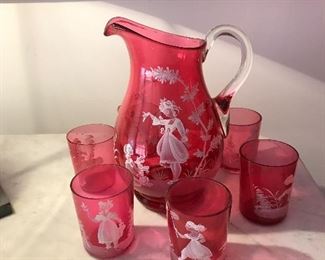 Highly sought after, this Water Set (Pitcher and 6 glasses) in Cranberry Glass is Hand-painted and the work of Mary Gregory.