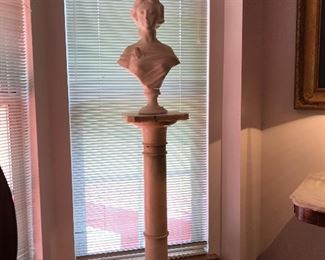 A tall, slender Marble Pedestal supports an Alabaster Bust of a young woman. 