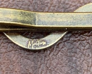 Detail of maker on tie clasp.