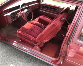 Red velvet highlights the Interior of this vintage 1986 Cadillac Coupe DeVille.