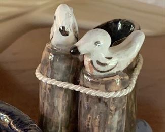 Small ceramic seagulls sitting on pier 