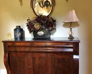 mahogany buffet,mirror, brass candle sconces, planter floral arrangement, biscuit tin, lamp