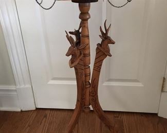 Slender pedestal table with carved figural animal heads