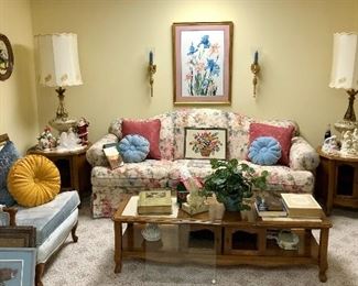 Lower level family room, marble top tables, blue velvet chair , floral sofa, retro lamps