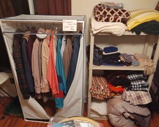 Various coats, a portable closet, bed linens