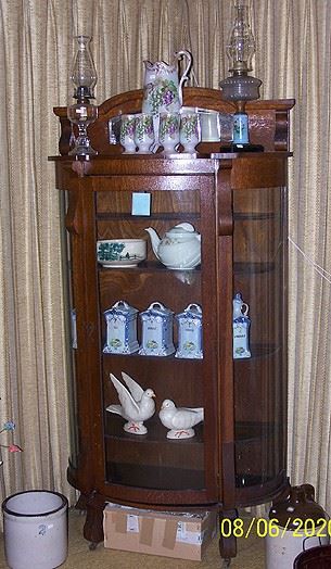 Oak china cabinet w / mirror top (37 in. W x 13 in. D x 70 in. H) , oil lamps, cannister set, Haeger doves, crock and jug, etc...