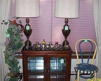 Small lighted display case, 2 brass lamps, painted bentwood chair, cast iron candle holder, car bank collection