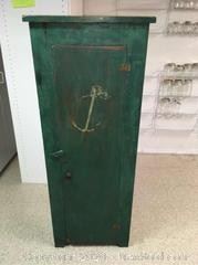 Green painted antique cabinet with an anchor painted on the front of the door.