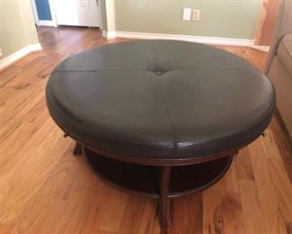 Brown leather ottoman with 4 slide-outs, wooden base.