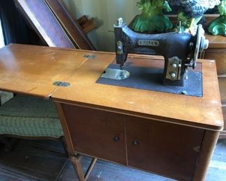 White sewing machine with cabinet.