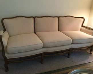 80" long, three cushion couch w/wood frame.  Color is a soft off white in file upholstery.  Lovely and comfortable.