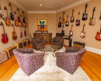 Art on Wall NOT FOR SALE! The Marshall Amp and Slant Cabinet in the back right is for sale. Fender Amps not for Sale! 20 Guitars are for Sale and their photos are below. Stay tuned for more SPECIFIC Amp & Guitars Photos coming in the future.
* ———
Lot #120 —  Oval and Glass Coffee Table — 33” x 51” x 19” Tall + 
* ———
Lot #121 — Four (4) Sam Moore Living Room Paddy Swivel Glider Armchairs — 34” wide at front x Seat is 19” high x 34” from wall x 32” Tall in Back
