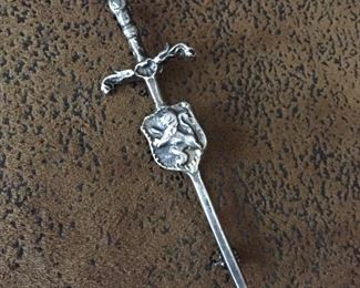 Vintage sterling silver long sword brooch, size 7/8" w x 2 3/4" h. Signed with very faded British hallmark stamps - there are four of them, plus an RA stamp. Stamps look like a lantern, a clover, a wolf face and a 1. Rolling c-clasp works perfectly. $180