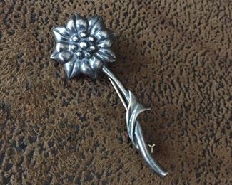 Vintage sterling silver flower brooch, size 2" h by 3/4" w. Signed with a mark that looks like a conjoined DMD, stamped with a copyright symbol and 925. $88