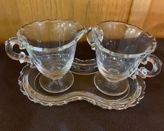 Glass cream and sugar set on a tray