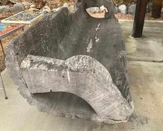 Side view of natural edge rustic carved bench from a single log