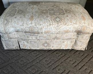 Custom upholstered skirted ottoman.
