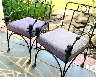 pair of wrought iron chairs with dog head accents 