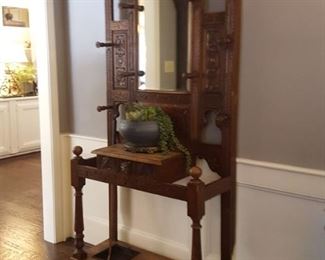 Ornate hall tree with beveled mirror, umbrella drip pans and glove box