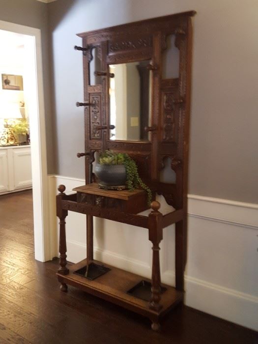 Ornate hall tree with beveled mirror, umbrella drip pans and glove box