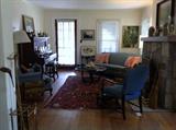 View of Wiley Avenue living room:  tiger oak upright piano, upholstered chairs, oriental rug, cane stand with root cane and wood golf club.