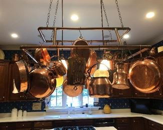 Tons of copper cookware and a two-tier copper pot rack