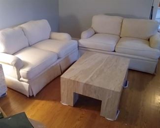Pair of ivory loveseats. Marble cocktail table