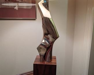 A fantastic pair of 1963 mid-century modern abstract cast metal and rosewood table lamps by American designer Richard Barr for Laurel Lamp Company (1950 - 1979) of chrome/rosewood, with original shades; dimensions:  5"W x 42"T x 5"D.                                                                      Artfully executed sculpture-like body of satin polished cast metal (appears to be aluminum or nickel) with protective clear coat. Facets, angles, and smoothly contoured surfaces appear to morph into entirely new forms as light source and perspective change. On well-proportioned rectangular rosewood veneer plinth.