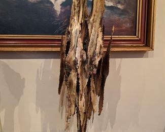 Brutalist metal sculpture on wooden base.