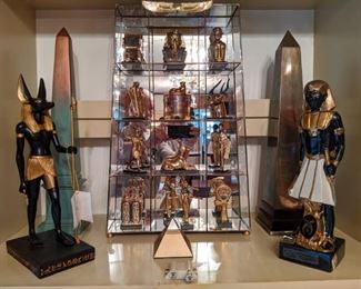 13-piece set of Franklin Mint Egyptian Treasures collection, in mirrored display case, pair of obelisks,  2001 composite Anubis statue (canine God of the Dead) and a 1979 porcelain Ezra Brooks "Imperial Council" whiskey decanter, by Heritage China.
