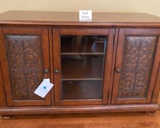 Lot 2110. $575.00. Beautiful Hooker Media Center Console. 2 Wood Cabinet Doors and 1 Glass Cabinet in the center, 2 Shelves in each section. This console credenza is superbly crafted and the perfect combination of form and function; great storage, can use in any room of house, can hold a large flat screen tv comfortably and has tremendous good looks and design. Whether your taste is conventional, eclectic, modern or vintage, this piece will shine in any setting. Measures 59" L x 23" x 36" H. You had better buy it now; it will not last!