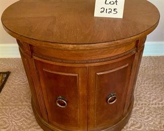 Lot 2125 $95.00 Thomasville Drum Table, with a delicately carved accent. The cabinet opens with double doors, for great storage within. There is a water stain on the top. 24.5" Diameter x 22" H. For half price this is a steal!