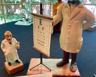 Lot 2137 $50.00 Ophthalmologist wood carvings. First is Dr. with an eye chart and an Ophthalmologist wood carving of a Dr with a magnifying glass and the verbiage, "I'm crazy about your eyes, madam." Made in Austria by Jaschke Preizel 11"H x 7" base