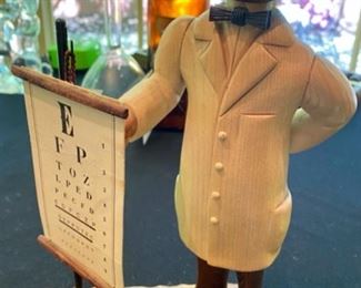 Lot 2137 $50.00 Ophthalmologist wood carvings. First is Dr. with an eye chart and an Ophthalmologist wood carving of a Dr with a magnifying glass and the verbiage, "I'm crazy about your eyes, madam." Made in Austria by Jaschke Preizel 11"H x 7" base