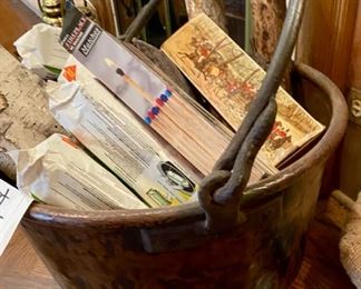 Lot 2165 $375.00 Large, antique hammered copper cauldron with forged iron handle, filled with logs and fireplace matches. 24"d x 12"h