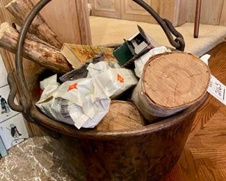 Lot 2165 $375.00 Large, antique hammered copper cauldron with forged iron handle, filled with logs and fireplace matches. 24"d x 12"h