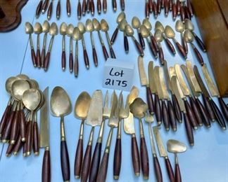 Lot 2175. $195.00. Vintage Brass with Rosewood Handled Flatware. 12 place settings; each setting has 11 pieces which include a steak knife, there are 12 additional serving pieces for a total of 144pcs. There is a storage box that is in rough shape but contains a storage area & covered drawer. Possible old Thailand/Siam flatware, not marked.